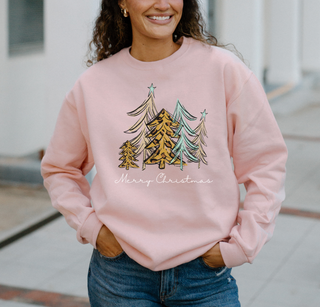Person wearing a pink sweatshirt with Christmas tree design and 'Merry Christmas' text.