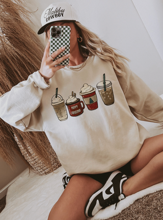 Person wearing a beige sweatshirt with coffee cup graphics and a checkered phone case.