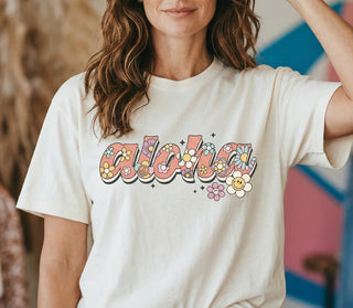 Person wearing a white t-shirt with 'aloha' design in colorful letters.
