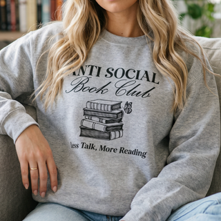 Person wearing a gray sweatshirt with 'Anti Social Books Club' design.