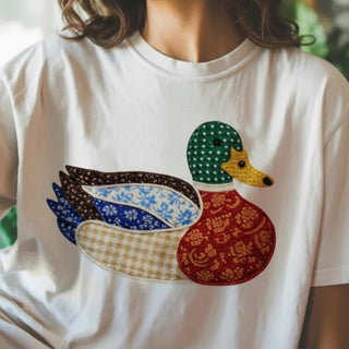 White t-shirt with a colorful duck design on a blurred background