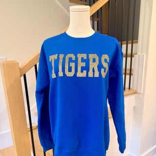 Blue sweatshirt with 'TIGERS' text on a mannequin against a staircase background