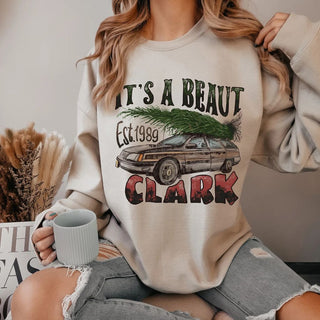 Person wearing a sweatshirt with a graphic design and text, holding a mug.